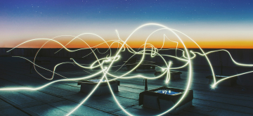 lichtflitsen boven een dak bij een donkere avondlucht