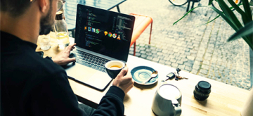 man drinkt koffie met laptop in café in Brugge