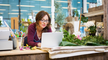 Florist in bloemenwinkel met laptop